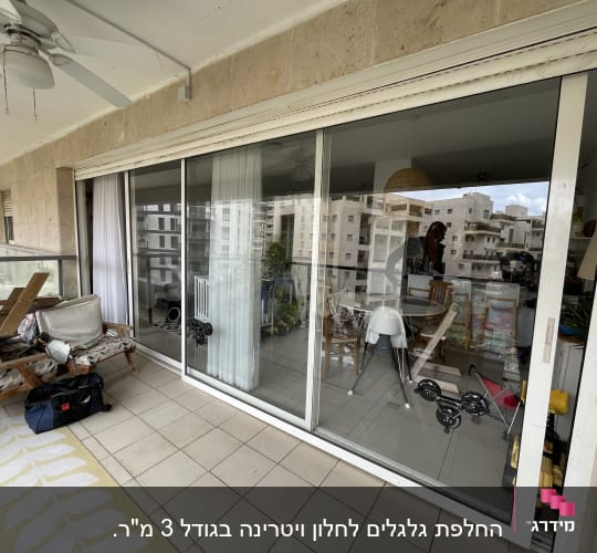 תריסים לבנים סגורים על חלון זכוכית במרפסת